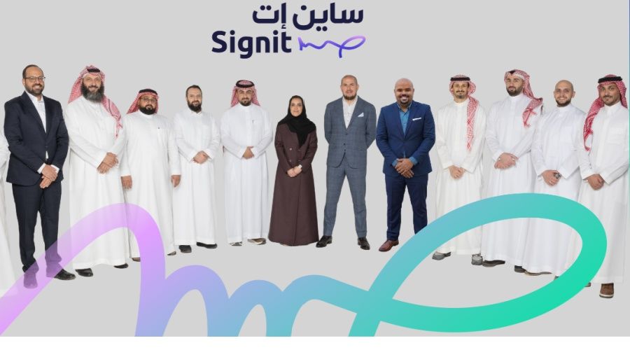 Signit team and investors standing together in front of the company logo at a launch event in Saudi Arabia
