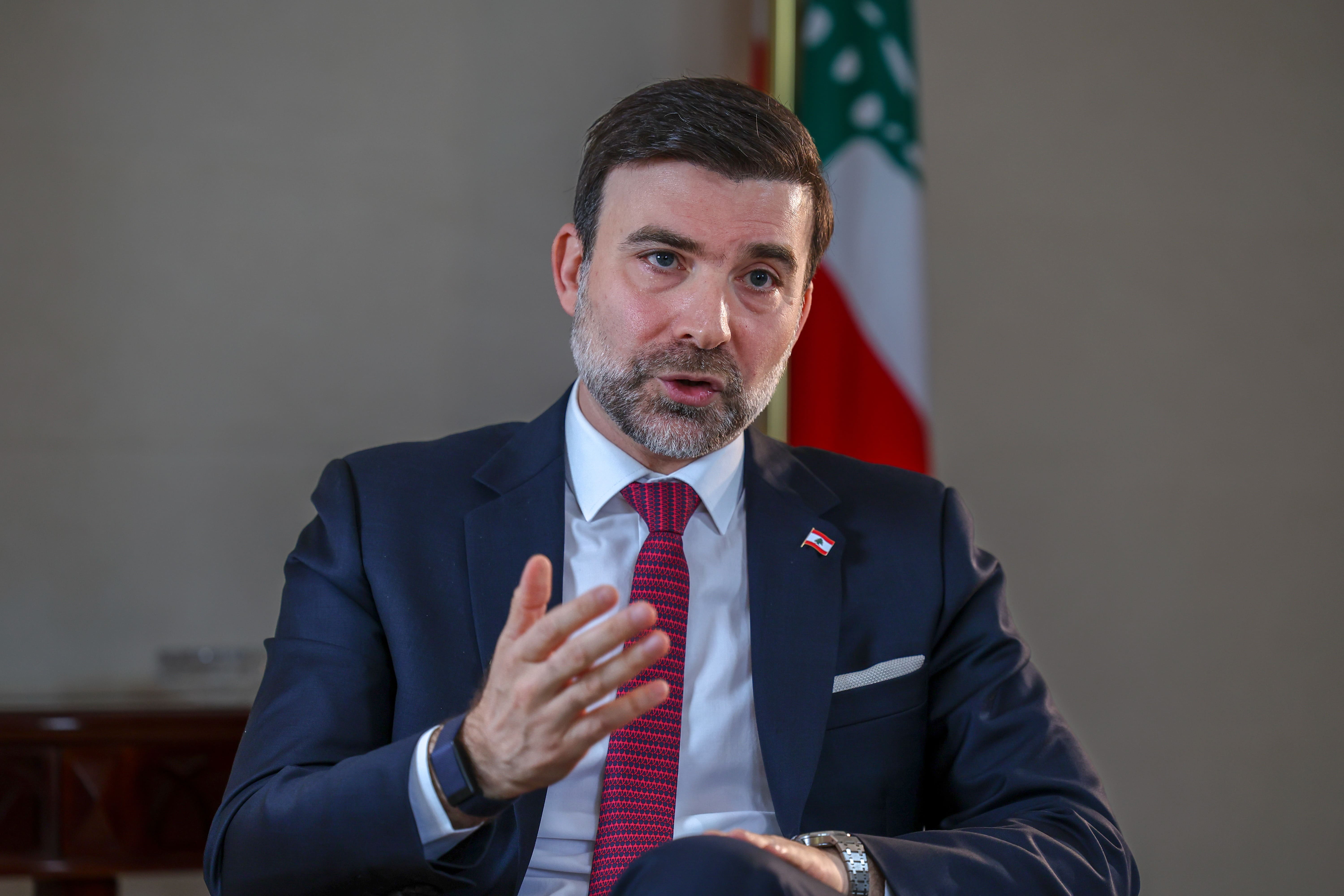 Tarek Mneimneh, Lebanon's ambassador to the UAE, speaking during an interview with a Lebanese flag behind him