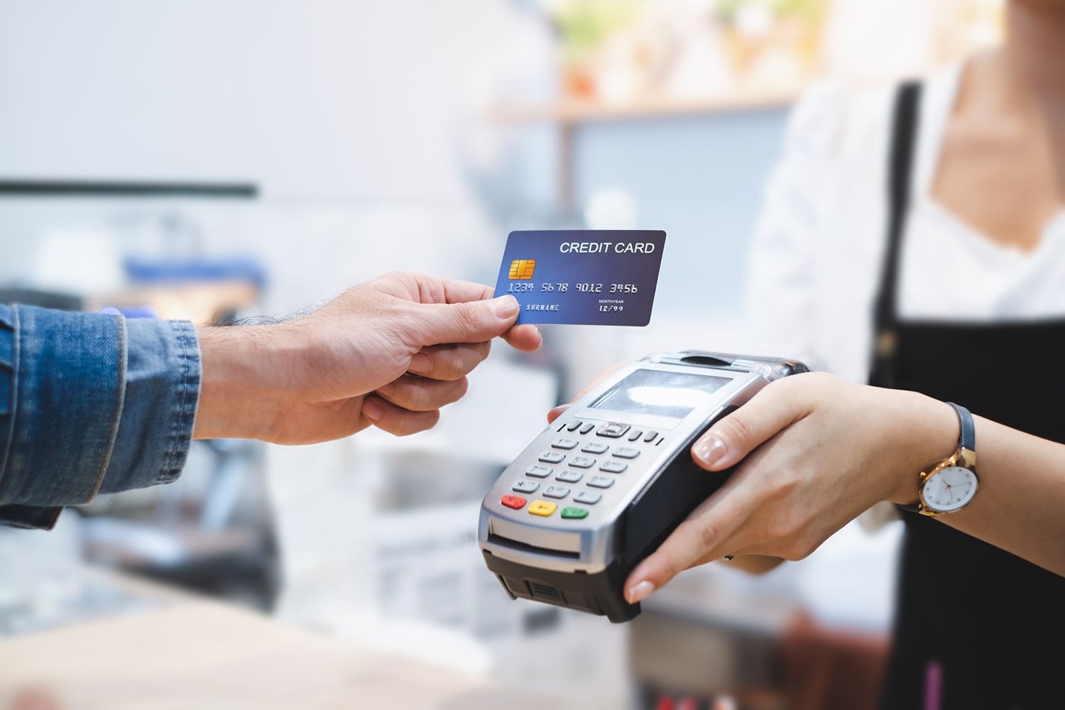 A hand holding a bank card at a point of sale terminal in a Beirut shop