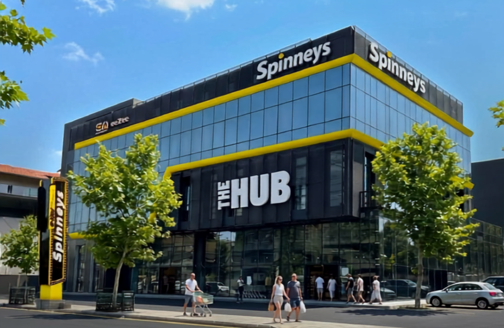The new Spinneys branch in Amioun, a multi-floor store with a yellow The Hub facade, with shoppers arriving on opening day.