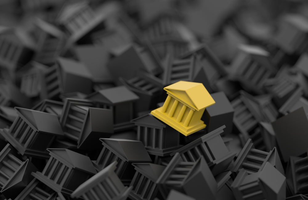 A single yellow bank building icon standing out among a dense pile of identical dark grey bank icons