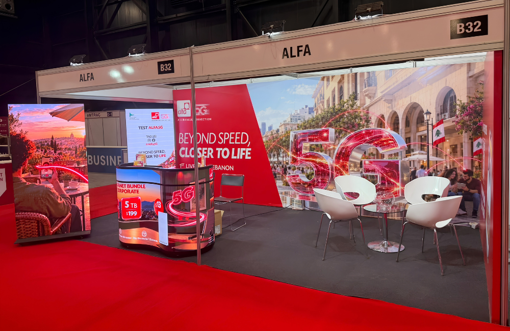Alfa's red and white booth B32 at Project Lebanon, with a large 5G graphic over a Beirut street scene, the "Beyond Speed, Closer to Life" slogan, white lounge chairs and a 5G promo counter