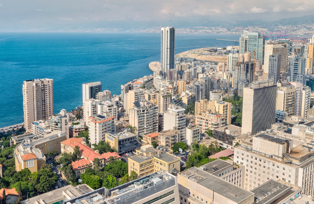 Aerial view of Beirut’s dense skyline of residential towers and apartment buildings along the Mediterranean coast, with the port and mountains in the background