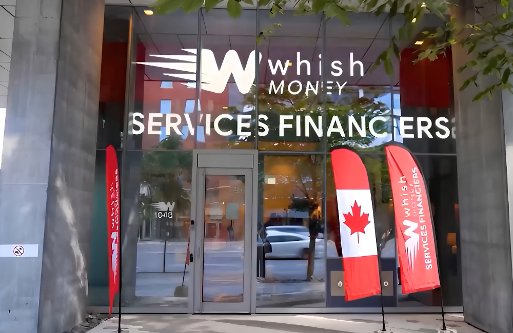 Storefront of the Whish Money branch in Montreal, with the Whish Money logo and “Services Financiers” in white letters across the glass facade. A Canadian flag banner and red Whish Money banners stand at the entrance.